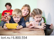 Мама пытается отобрать смартфоны у детей. Стоковое фото, фотограф Кекяляйнен Андрей / Фотобанк Лори