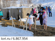 Девушка осторожно входит в ледяную воду. Крещенские морозы (2014 год). Редакционное фото, фотограф Александр Тараканов / Фотобанк Лори