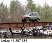 Автомобиль "УАЗ" переезжает реку по мосту из двутавровых балок (2008 год). Редакционное фото, фотограф Евгений Ткачёв / Фотобанк Лори