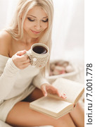 Young woman reading a book with a Cup of coffee in his hands. Стоковое фото, фотограф Александр Савченко / Фотобанк Лори