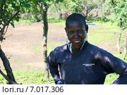 Meserani Snake Park, Arusha, Tanzania - February 14, 2008: Unknown black african woman from the maasai tribe in shabby clothes, smiling with her arms akimbo. Чернокожая африканская женщина племени масаи, в одежде из гуманитарной помощи, улыбается. Аруша, Танзания. Редакционное фото, фотограф Владимир Григорьев / Фотобанк Лори
