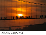 Люди на мосту Ram Jhula на закате. Ришикеш, Индия (2014 год). Стоковое фото, фотограф Elena Odareeva / Фотобанк Лори