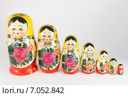 Семь традиционных русских матрешек по убыванию в ряд на белом фоне (2015 год). Редакционное фото, фотограф Александр Степанов / Фотобанк Лори