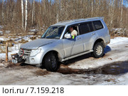 Внедорожный автомобиль Мицубиси Паджеро застрял передними колесами в лесном ручье на ледяной,  проселочной дороге (2015 год). Редакционное фото, фотограф Владимир Григорьев / Фотобанк Лори