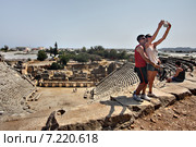 Greek theater in ancient town of Myra, Antalya region, Turkey Двое молодых туристов делают селфи на фоне древнего амфитеатра в городе Мира, Анталия Турция (2014 год). Редакционное фото, фотограф Владимир Григорьев / Фотобанк Лори