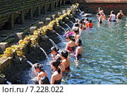 Balinese Hindu families come to the sacred springs of Tirta Empul in Bali, Indonesia to pray and cleanse their soul. Редакционное фото, агентство BE&W Photo / Фотобанк Лори
