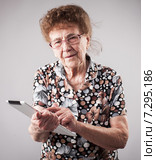 Old woman holding a tablet in the hands of. Стоковое фото, фотограф Гладских Татьяна / Фотобанк Лори