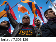 Армянские мужчины держат национальные флаги Армении во время митинга в день памяти жертв геноцида армян в 1915 году на территории Османской империи в парке имени Горького в Москве, Россия (2015 год). Редакционное фото, фотограф Николай Винокуров / Фотобанк Лори