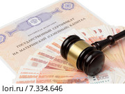 Судейский молоток лежит на деньгах и сертификате на материнский капитал. Стоковое фото, фотограф Денис Ларкин / Фотобанк Лори