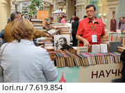 Московские букинисты подбирают себе старую  книгу в ГУМе (2015 год). Редакционное фото, фотограф Дмитрий Неумоин / Фотобанк Лори