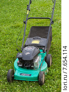 Бензиновая самоходная газонокосилка Briggs&Stratton стоит на зелёной траве (2015 год). Редакционное фото, фотограф Lora / Фотобанк Лори