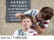 Проблемы со зрением. Мама смотрит на сына примеряющего очки. Стоковое фото, фотограф Pukhov K / Фотобанк Лори