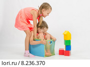 Девочка пытается вытащить другую девочку из коробки. Стоковое фото, фотограф Иванов Алексей / Фотобанк Лори