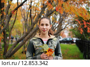 Девочка с кленовыми листочками в руках в парке осенью. Стоковое фото, фотограф Ирина Здаронок / Фотобанк Лори