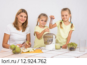 Счастливая семья приготавливает свежеотжатый сок в соковыжималке. Стоковое фото, фотограф Иванов Алексей / Фотобанк Лори