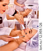 Group women receiving electric hydradermie massage at beauty salon. Стоковое фото, фотограф Gennadiy Poznyakov / Фотобанк Лори