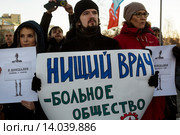 Мужчина держит плакат с надписью "Нищий врач - больное общество" на митинге в защиту здравоохранения "Право на жизнь!" на Суворовской площади города Москвы (2015 год). Редакционное фото, фотограф Николай Винокуров / Фотобанк Лори
