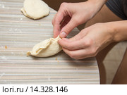 Женские руки скрепляют шов пирожка на столе в кухне. Стоковое фото, фотограф Иванов Алексей / Фотобанк Лори