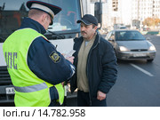 Сотрудник ДПС проверяет документы у водителя грузового автомобиля на городской улице (2013 год). Редакционное фото, фотограф Михаил Михин / Фотобанк Лори
