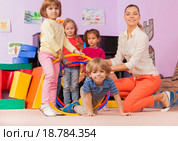 Учитель и дети играют с обручами в классе детского сада. Стоковое фото, фотограф Сергей Новиков / Фотобанк Лори