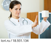 Serious female physician warning of faulty drugs. Стоковое фото, фотограф Яков Филимонов / Фотобанк Лори