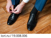 Мужчина завязывает шнурки на ботинках. Стоковое фото, фотограф Игорь Низов / Фотобанк Лори