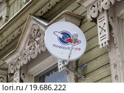 Спутниковая антенна Национальной спутниковой компании Триколор ТВ установлены на старинном деревянном доме в провинциальном городе России на фоне резных наличников (2016 год). Редакционное фото, фотограф Николай Винокуров / Фотобанк Лори