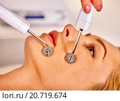 Young woman receiving electric facial massage. Стоковое фото, фотограф Gennadiy Poznyakov / Фотобанк Лори