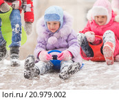 Две веселых девочки катятся с горки друг за другом с ледяной горки. Стоковое фото, фотограф Иванов Алексей / Фотобанк Лори