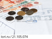 Квитанции на оплату коммунальных услуг с подчёркнутой итоговой суммой и российскими деньгами (2016 год). Редакционное фото, фотограф Игорь Низов / Фотобанк Лори