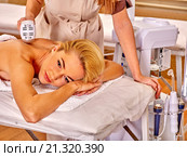 Young woman receiving electric back massage. Стоковое фото, фотограф Gennadiy Poznyakov / Фотобанк Лори