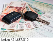 Страхование автомобиля. Автомобильный ключ и деньги лежат на страховом полисе ОСАГО. Стоковое фото, фотограф Игорь Низов / Фотобанк Лори