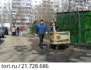Рабочие коммунальной службы везут мусор с картонной коробке на тележке. Алтайская улица. Район Гольяново. Москва (2009 год). Редакционное фото, фотограф lana1501 / Фотобанк Лори
