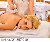 Young woman receiving electric back massage. Стоковое фото, фотограф Gennadiy Poznyakov / Фотобанк Лори