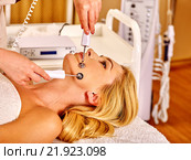 Young woman receiving electric facial massage. Стоковое фото, фотограф Gennadiy Poznyakov / Фотобанк Лори