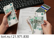 Девушка подсчитывает заработанные деньги на фоне трудового договора. Стоковое фото, фотограф Игорь Низов / Фотобанк Лори