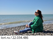Девушка сидит на берегу моря весной (2015 год). Редакционное фото, фотограф Наталья Краснобаева / Фотобанк Лори