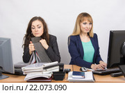 Девушки коллеги в офисе, одна уснула на папке, вторая счастливая работает в компьютере. Стоковое фото, фотограф Иванов Алексей / Фотобанк Лори