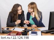 Молодые офисные девушки в перерыв увлеченно обсуждают губную помаду за рабочим столом. Стоковое фото, фотограф Иванов Алексей / Фотобанк Лори