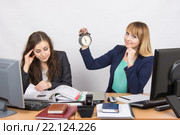В офисе одна сотрудница с нетерпением ждет конца рабочего дня, а другая продолжает интенсивно работать. Стоковое фото, фотограф Иванов Алексей / Фотобанк Лори