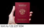 Паспорт Российской Федерации в руке на черном фоне. Стоковое фото, фотограф Вячеслав Сыпченко / Фотобанк Лори