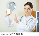 Serious female physician warning of faulty drugs. Стоковое фото, фотограф Яков Филимонов / Фотобанк Лори