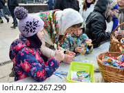 Молодая девушка - мастер учит детей изготавливать соломенную фигурку Масленицы на мастер-классе на Московской площади в Санкт-Петербурге (2016 год). Редакционное фото, фотограф Максим Мицун / Фотобанк Лори
