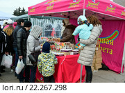 Дети с родителями покупают сладости в уличной палатке на празднике Масленицы на Московской площади в Санкт-Петербурге (2016 год). Редакционное фото, фотограф Максим Мицун / Фотобанк Лори