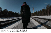 Женщина идет зимой по железной дороге в лесу, уходит вдаль. Стоковое видео, видеограф Кекяляйнен Андрей / Фотобанк Лори