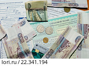 На столе лежат полис ОСАГО, полис КАСКО, уведомление о дорожно-транспортном происшествии, банковские карты, деньги, купюры, монеты (2016 год). Редакционное фото, фотограф Юрий Карачев / Фотобанк Лори