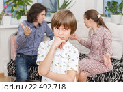 Расстроенный мальчик, родители ссорятся на диване. Стоковое фото, фотограф Юлия Кузнецова / Фотобанк Лори