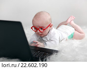 Смешной увлеченный ребенок в очках с компьютером. Стоковое фото, фотограф Элина Гаревская / Фотобанк Лори