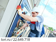 builders worker installing glass windows on facade. Стоковое фото, фотограф Дмитрий Калиновский / Фотобанк Лори