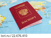 Российский заграничный паспорт лежит на атласе мира. Стоковое фото, фотограф Игорь Низов / Фотобанк Лори